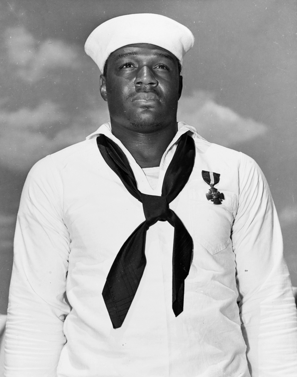 in this file photo taken may 27, 1942, mess attendant 2nd class doris miller stands at attention after being awarded the navy cross medal for for his actions aboard the battleship uss west virginia (bb-48) during the dec. 7, 1941 japanese attack on pearl harbor. the medal was presented to miller by adm. chester nimitz aboard the aircraft carrier uss enterprise (cv-6) during a ceremony in pearl harbor, hawaii. (u.s. navy photo)