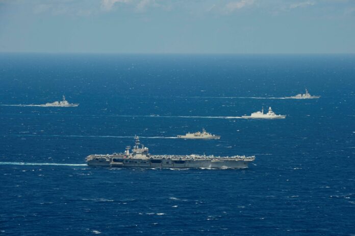 The Hellenic Hydra-class frigate Psara (F 454), center front, and the Italian Carlo Bergamini-class frigate Virginio Fasan (F 591), center, sail in formation with ships assigned to the IKE Carrier Strike Group in the Mediterranean Sea, March 11, 2021.